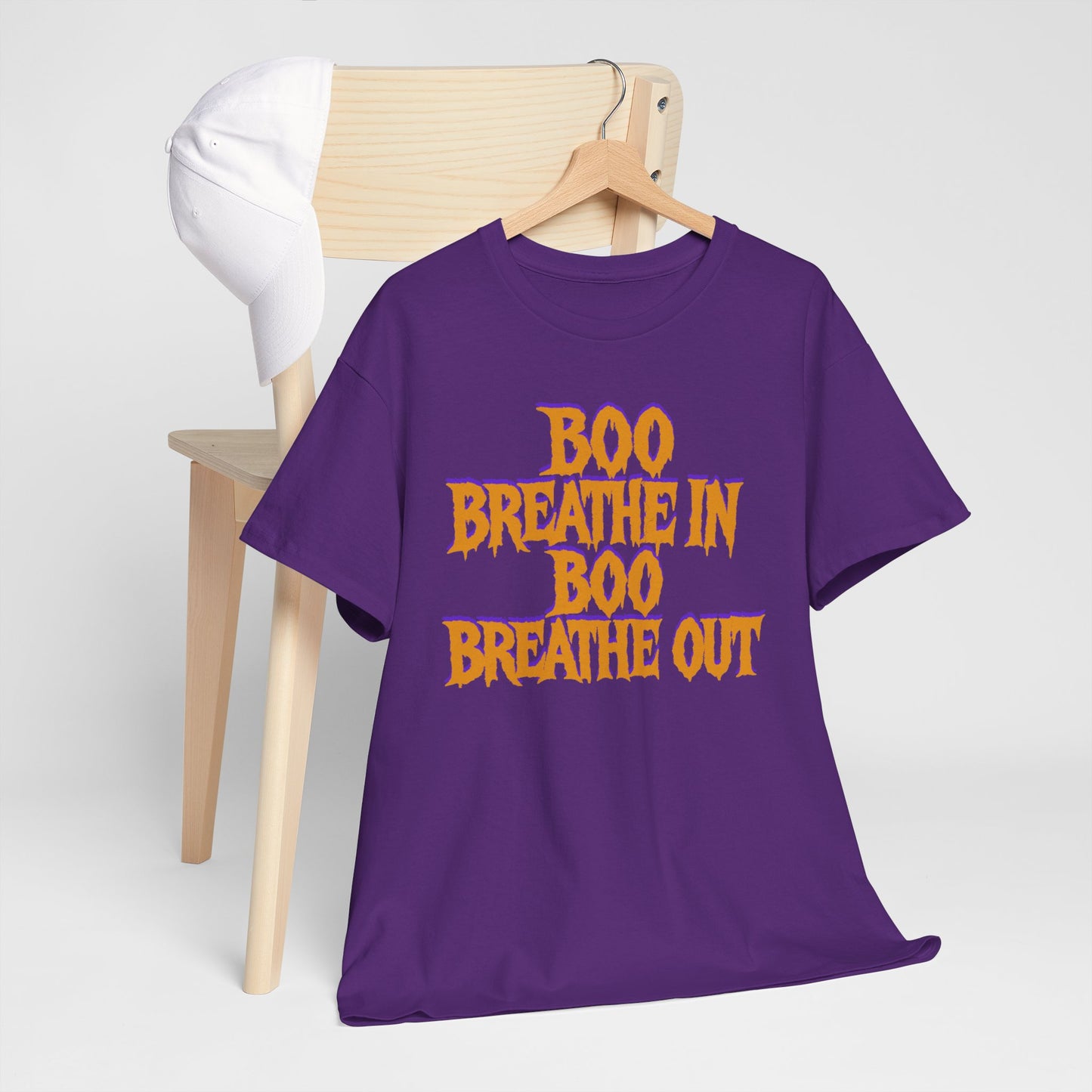 Purple t-shirt with 'BOO BREATHE IN BOO BREATHE OUT' text on a wooden hanger against a white background
