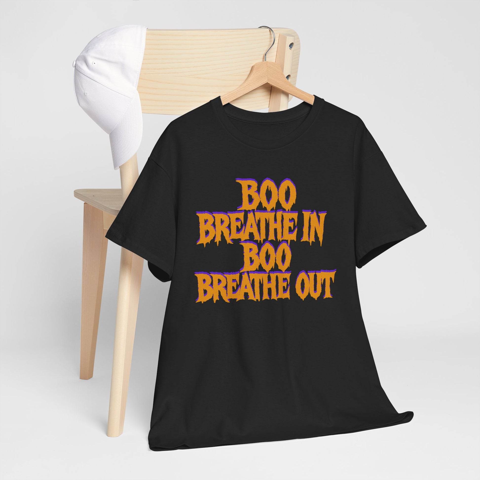Black t-shirt with 'BOO BREATHE IN BOO BREATHE OUT' text on a wooden hanger against a white background